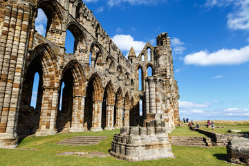 Fototapeta premium WHITBY, ENGLAND - AUGUST 12: Tourists visiting the ruins of Whitby Abbey. In Whitby, North Yorkshire, England. On 12th August 2016