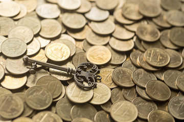 skeleton key lying on gold coins
