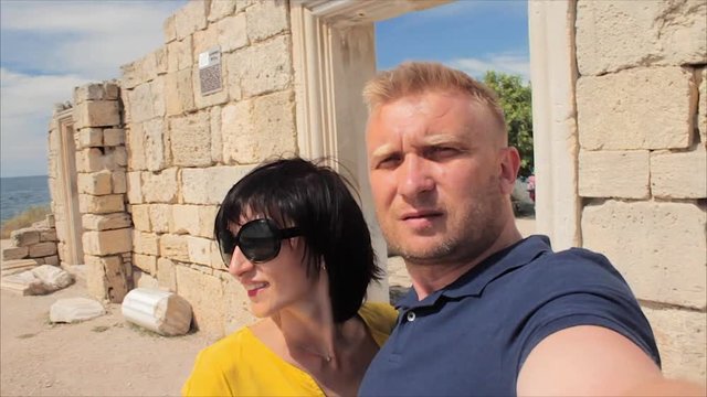 Attractive Happy Couple Taking Selfie on the ruins of the ancient city and sea beach background