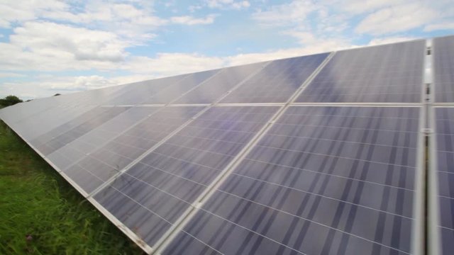 Sunlight gleams off solar panels in field - Stock Video