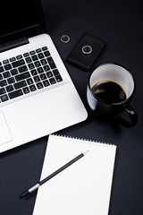 Businessman desk workspace with laptop keyboard, coffee and note