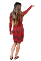Back view of  pointing woman. beautiful girl. Rear view people collection.  backside view of person.  Isolated over white background. The girl in red plaid dress shows an index finger upwards.