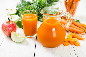 Carrot-apple juice on wooden background