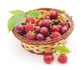 Cherries and raspberries in a basket.