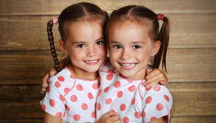 happy family children twin sisters hugging - obrazy, fototapety, plakaty