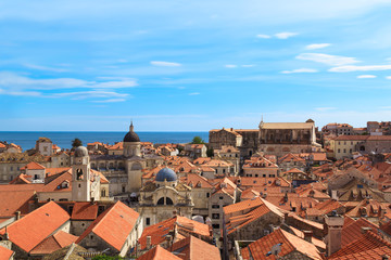 Fototapeta na wymiar Top view of the orange tile roofs and the sea in the Italian style in Dubrovnik, Croatia