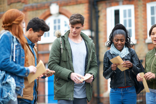 Young adult college students opening exam results on campus
