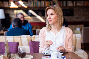 Woman in cafe drinking coffee, enjoying her espresso