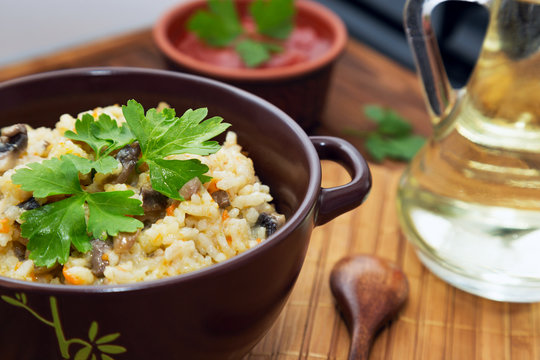 Rice with mushrooms and carrot or pilaf on wooden rustic table