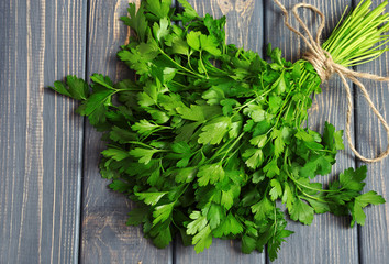 Fresh bunch of parsley closeup on wooden table. Top view