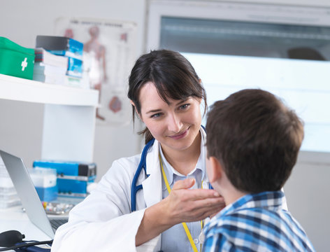 Doctor Checking For Swollen Glands On Boy's Neck