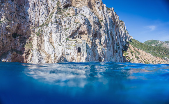 Above and below view of blue sea and cliffs, Masua, Italy
