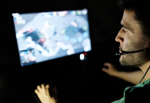Man playing video game in dark room
