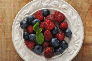 blueberries and raspberries with mint in bowl