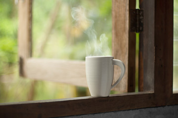 Hot drink coffee cup with smoke on old wooden windows