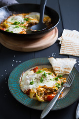 Shakshuka and pita. Scrambled eggs with vegetables and spices