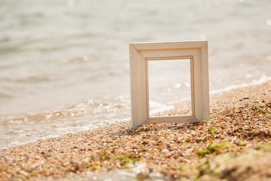 Photo frame on sand beach