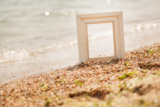 Photo frame on sand beach