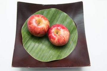  Red apple's two on with banana leaves