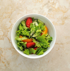 a salad of lettuce, tomatoes and cucumbers with sesame seeds