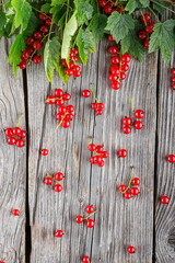 red currants with green leaves on wooden table, like the rain, creative idea for harvest