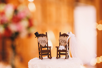 Little hat, veil and boquuet stand on toy rocking chairs put on
