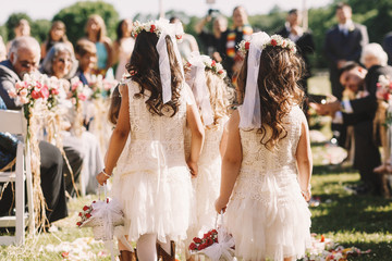 Look from behind at little girls walking along the path to weddi