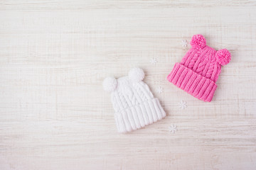 Two knitted baby hats with pompoms