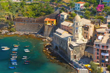 Aerial view with colorful fishing boats and Santa Margherita di Antiochia Church in Vernazza harbour in Five lands, Cinque Terre National Park, Liguria, Italy.