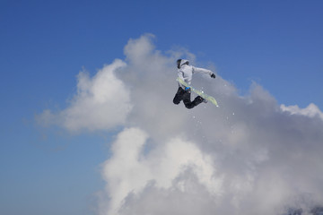 Snowboarder jumping in mountains, extreme sport.