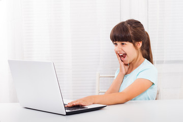 Excited little girl using laptop