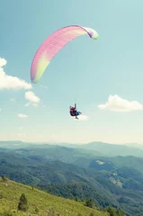 Tuinposter Tandem paragliding flight with hills and blue sky © Catalin Pop