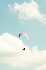 Paraglider in the sky in sun light and clouds