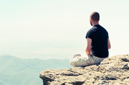 Young man relaxing on top of the mountain