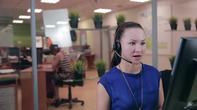 caucasian woman at a Call center in a bright clean office. HD.
