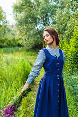 outdoor portrait of a beautiful brunette woman in blue dress in