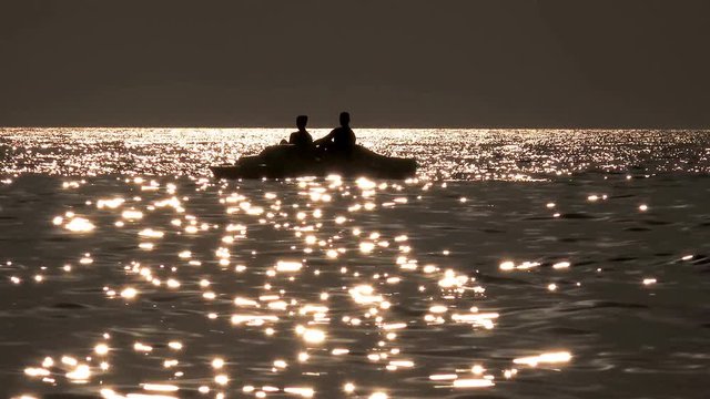  Beautiful seascape sunset with pedal boat silhouette refugee floating 