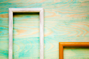 Old abstract picture frames on colored wooden background