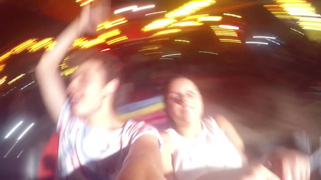 Two teens ride on the Ferris wheel, cheerful and happy 