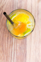 Lemonade juice with orange on wooden background