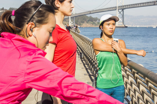 Runners stretching on urban bridge, San Francisco, California, United States