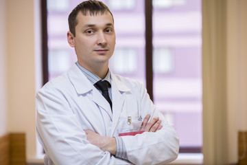 male physician closeup portrait with arms across