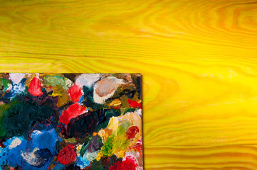 Fototapeta na wymiar Painting palette on colored wooden background