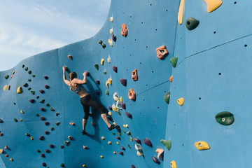 Young woman on climbing wall, Brooklyn Bridge Park, Brooklyn, New York, USA