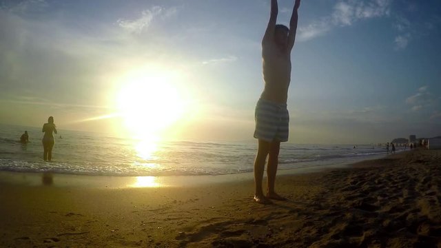 Gymnast beach backflip floor work at sunset. 