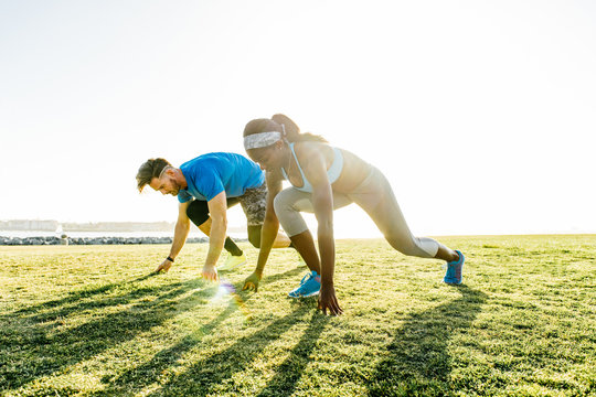Man and young woman training, on their marks on coast, downtown San Diego, California, USA