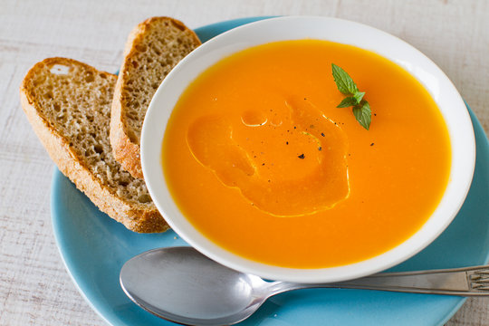 creamy smooth carrot soup on wooden table