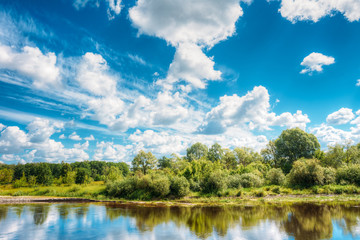 River Landscape With Reflections Of Clouds And Woods In Water.