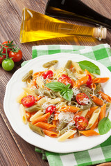 Colorful penne pasta with tomatoes and basil