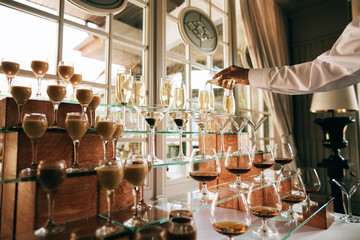 Catering service. Wedding drink bar. Waiter pouring champagne into a glass